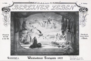 Ein Schwarz-Weiß-Foto einer Bühne der Wiesbadener Festspiele aus dem Jahr 1902, das Menschen in traditioneller deutscher Tracht zeigt, einige mit Hüten und andere mit Umhängen, unter bunten Lichtern und Dekorationen, während das Publikum im Hintergrund jubelt.