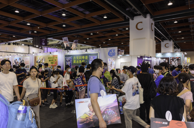 Große Besuchermenge auf der Hong Kong Games Expo 2020, einige halten Taschen und Schilder, vor einem Stand mit Bannern, einer Absperrung, einer Säule und Deckenleuchten.
