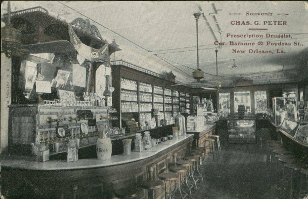 Altes Schwarz-Weiß-Foto eines Apothekeninneren in New Orleans mit Hockern, Tischen, Flaschen und Glasfenstern, mit Text oben.