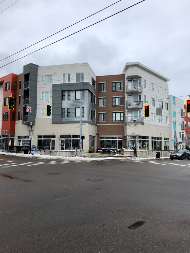 Stadtstraße mit parkenden Autos, Gebäuden, Laternen, Verkehrszeichen, Werbetafeln, Drähten und bewölktem Himmel im Hintergrund, die eine Eigentumswohnung/Townhouse zum Verkauf an 541 St Johns Ave Unit 541, Mississauga, Ontario, Kanada, bewerben.