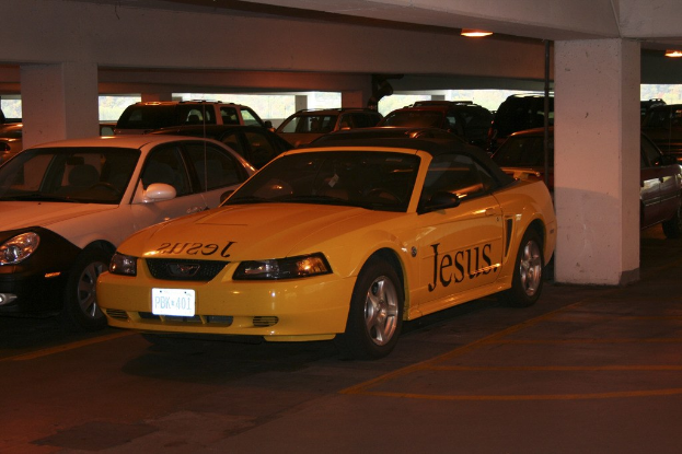 Ein vollbesetzter Parkplatz mit zahlreichen Autos vor einem Geb├Ąude.
