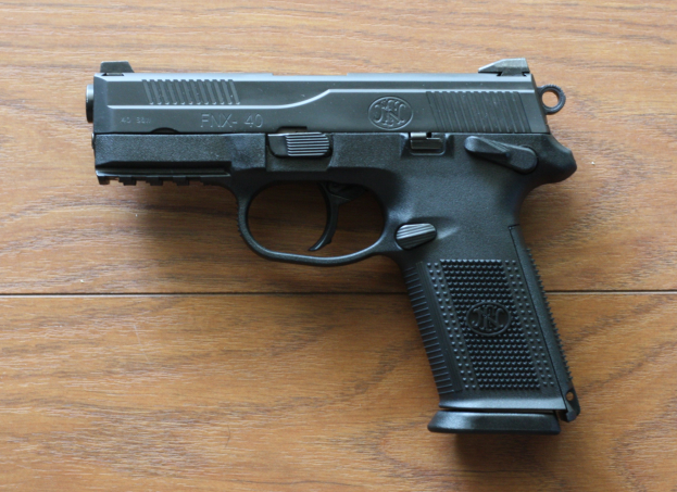 Eine Sig Sauer P226 X-Five 9mm Pistole auf einer schwarzen Oberfläche mit einem schwarzen Hintergrund.