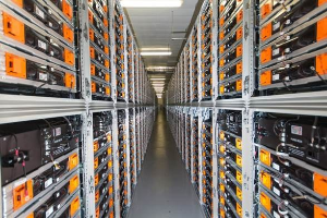 Lange Reihe von Serverregalen in einem Rechenzentrum mit elektronischen Geräten und Leuchten oben.