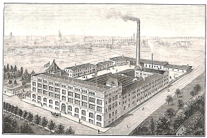 Ein altes Fabrikgebäude umgeben von Bäumen mit Text am unteren Bildrand.